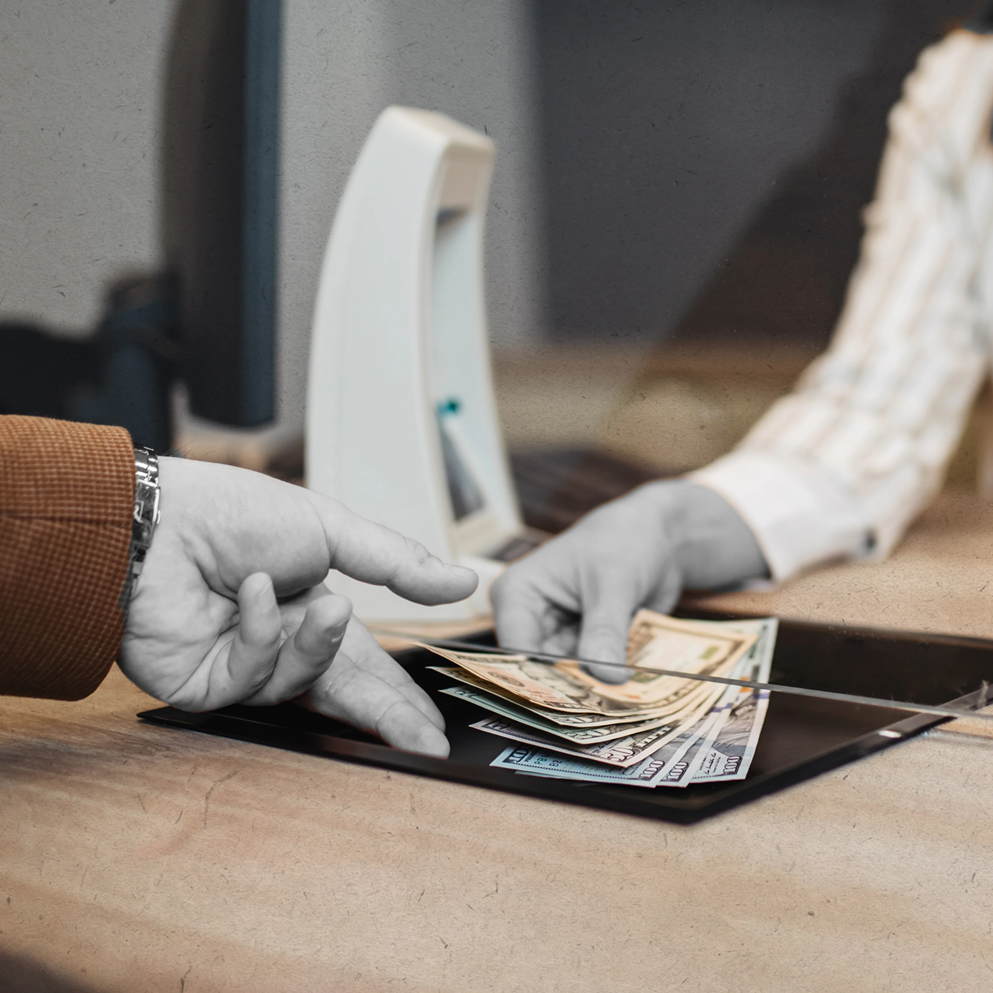 Image of a bank teller handing money to a customer